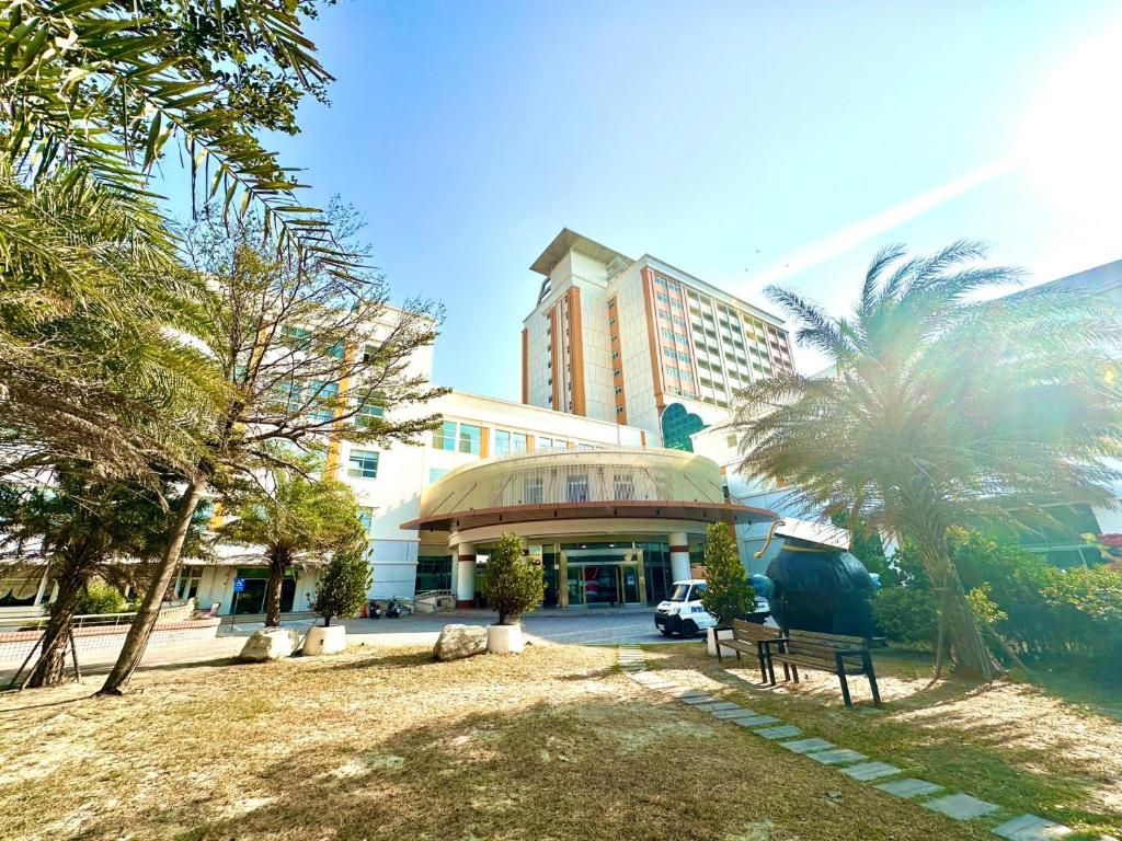 un parque frente a un edificio con palmeras en APAC Lukang Resort, en Lukang