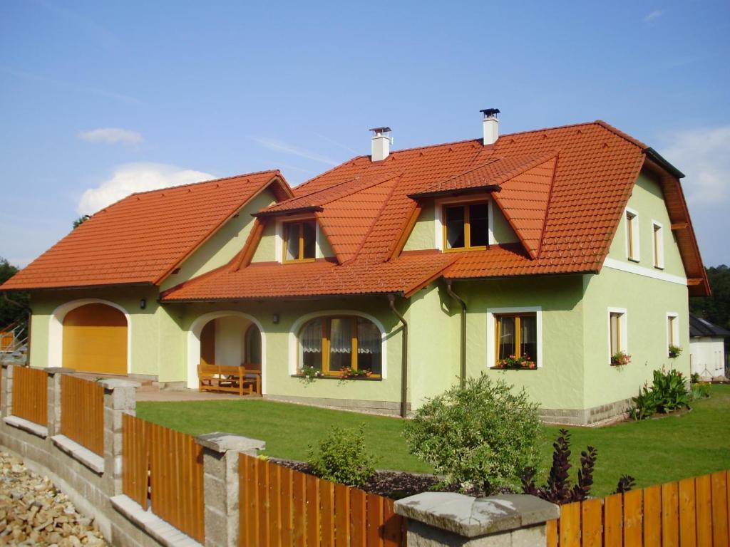 ein Haus mit einem orangenen Dach und einem Zaun in der Unterkunft Rodinný apartmán Rodvínov in Rodvínov