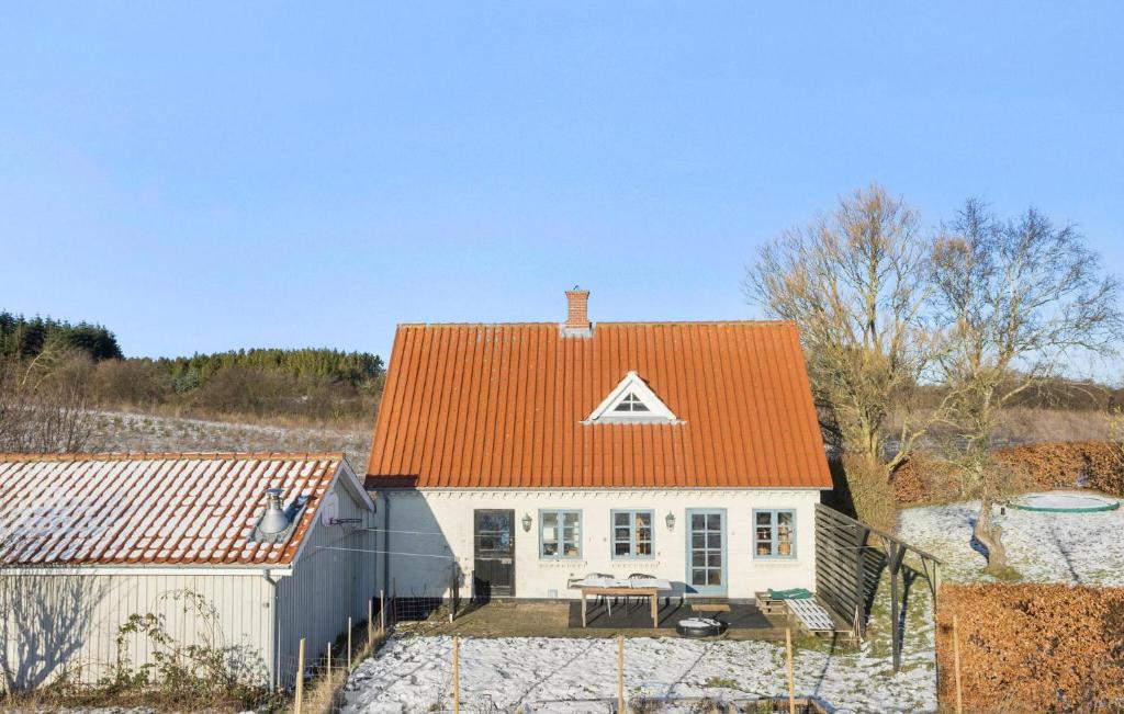 una pequeña casa blanca con techo naranja en Awesome Home In Tranekr With Kitchen, en Tranekær