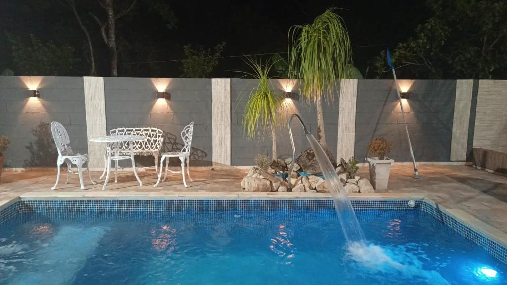 een zwembad met een tafel en stoelen en een fontein bij Recanto Itália Brasil in Biritiba-Mirim