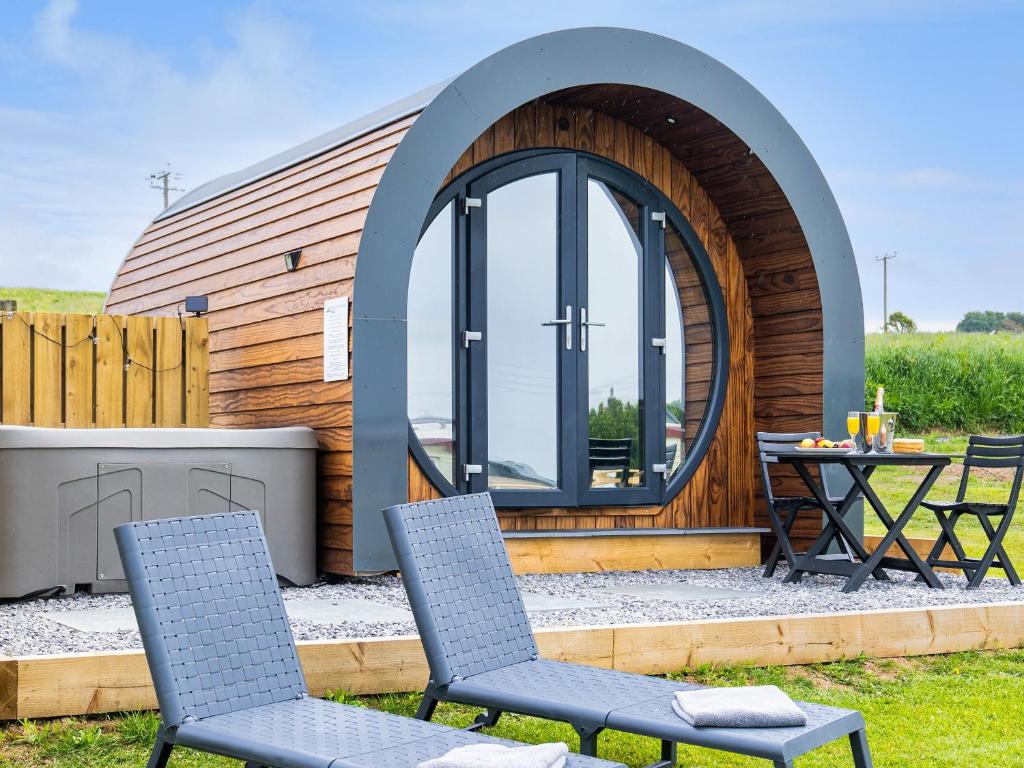 a circular building with two chairs and a table at Traeth Pod - Uk46077 in Gwbert