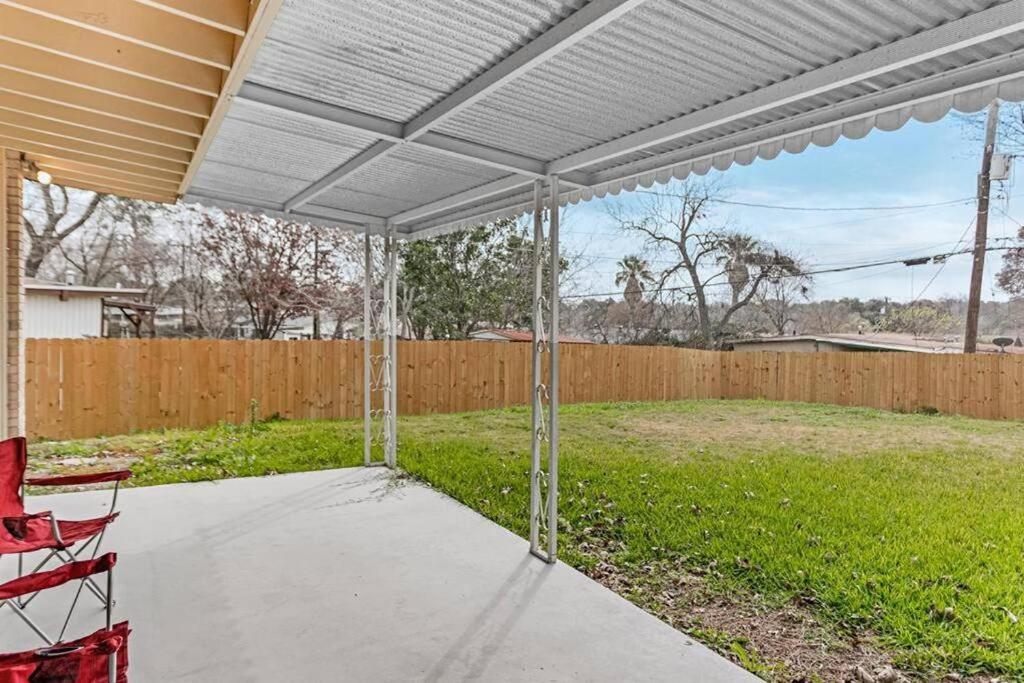 a covered patio with a red chair and a fence at Fenced backyard, king bed, near medical center, Aquarium, and SeaWorld in San Antonio