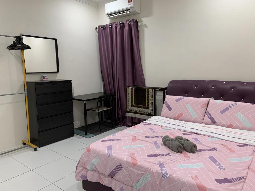 um quarto com uma cama com dois sapatos em Rosevilla Homestay - 3R2B Fully Aircond WiFi em Bandar Puncak Alam