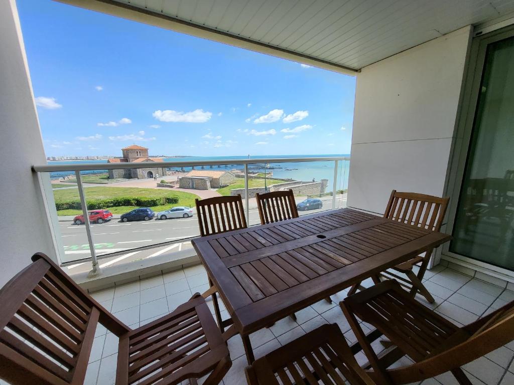 d'une table et de chaises sur un balcon avec vue sur la rue. dans l'établissement T2 avec terrasse, 500m de la plage, Les Sables-d'Olonne - FR-1-92-896, à Les Sables-dʼOlonne