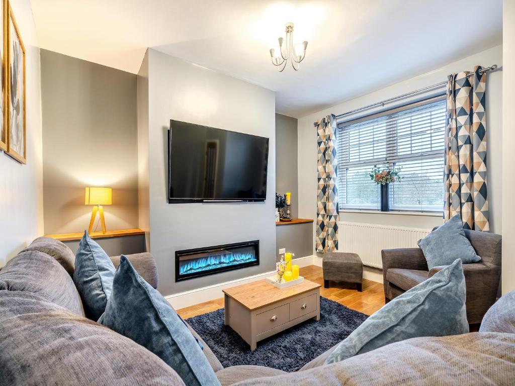 uma sala de estar com um sofá e uma lareira em Appletree Cottage em Cornsay