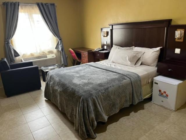 een slaapkamer met een groot bed en een raam bij Enclave Hotel Abuja in Kagini