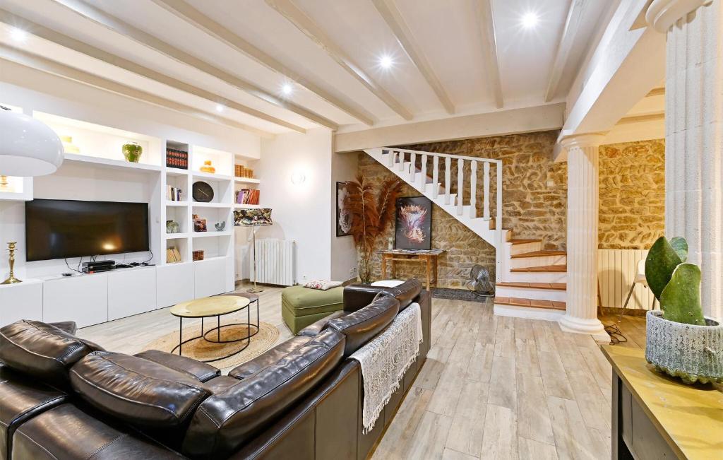 a living room with a leather couch and a staircase at Gorgeous Home In Bagnols-sur-cze With Kitchen in Bagnols-sur-Cèze