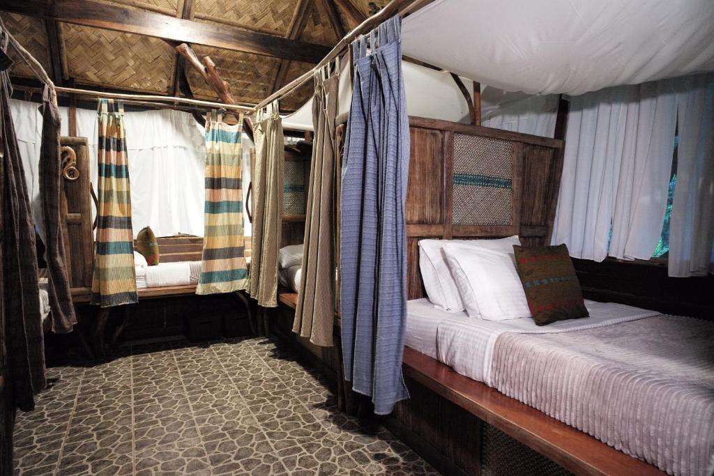 Un dormitorio con una cama en una tienda de campaña. en Banahaw Circle Nature Retreat, en Pinagdanglayan