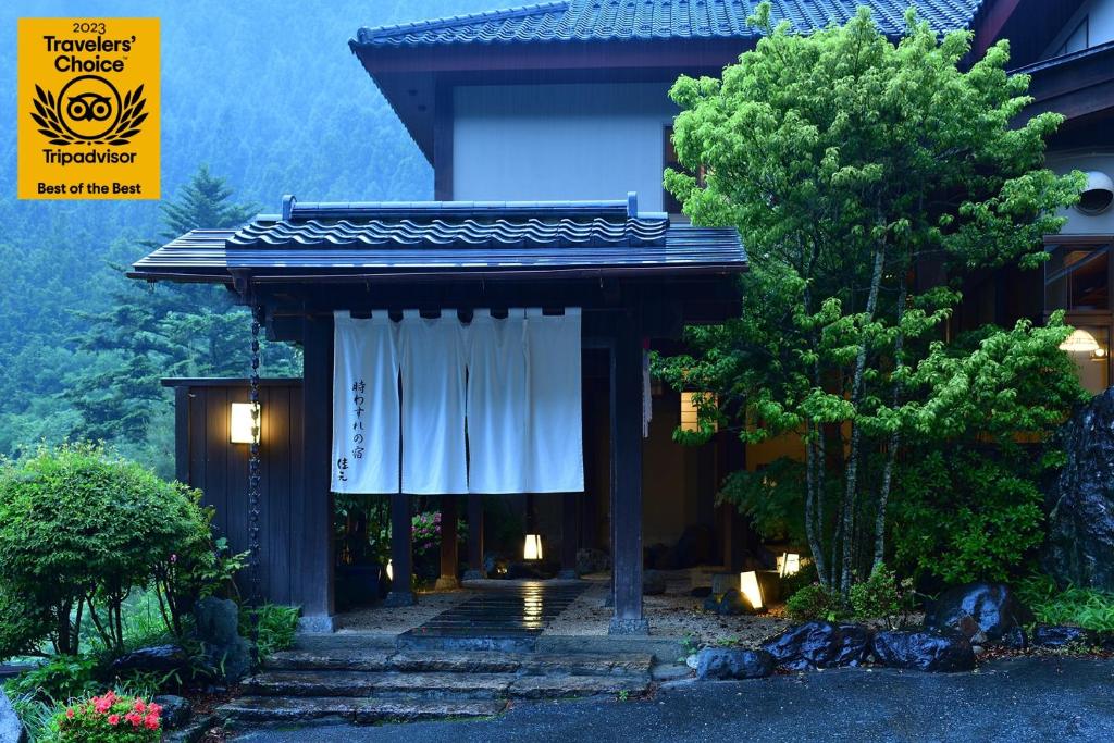 un edificio con una puerta con una cortina blanca en Shima Onsen Yoshimoto, en Nakanojo
