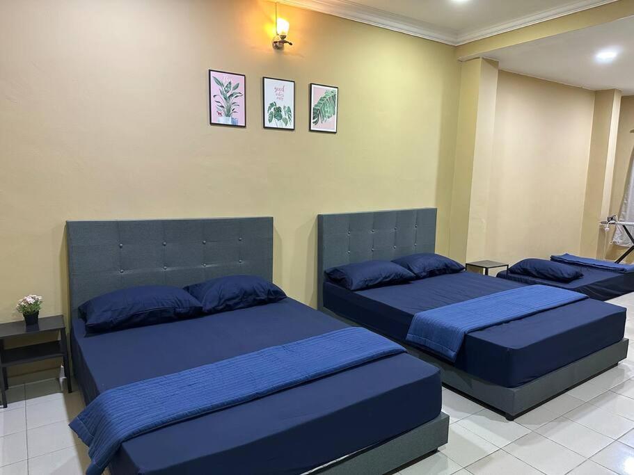 1 dormitorio con 3 camas con almohadas azules en ~Big House UITM Hospital 11 Pax~, en Shah Alam