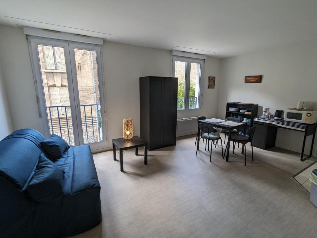 een woonkamer met een blauwe bank en een tafel bij Appartement Orléans, 2 pièces, 2 personnes - FR-1-590-362 in Orléans