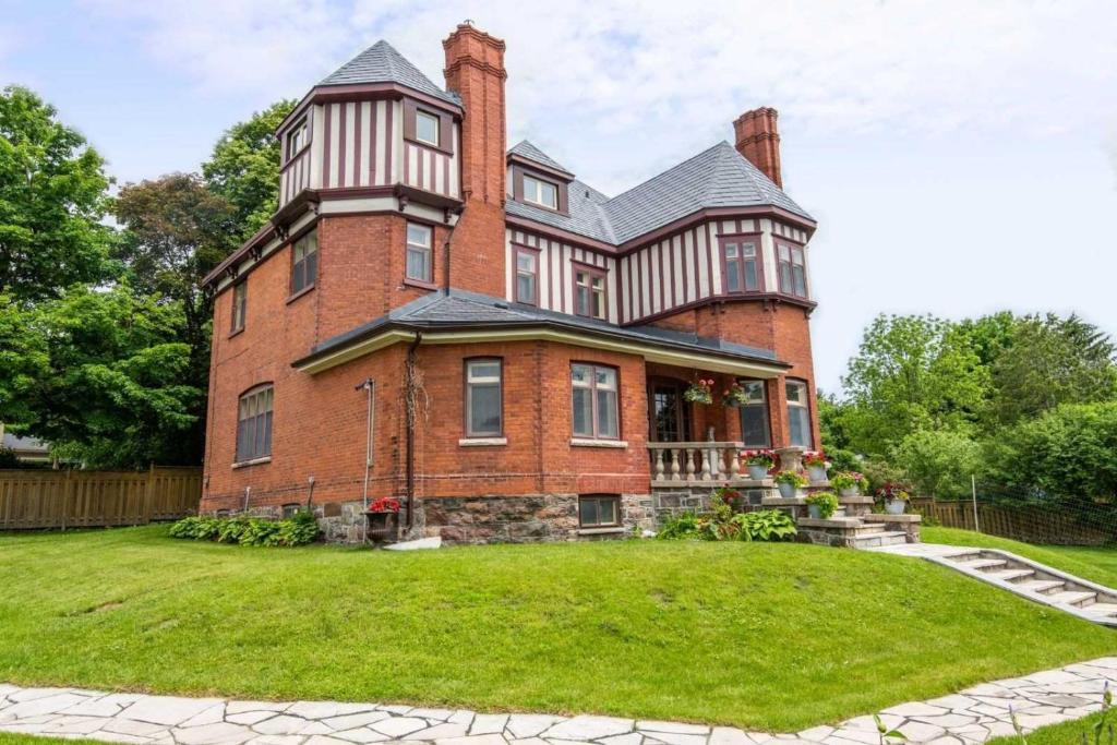a large brick house with a large yard at 2 bedroom apartment in historical home in Barrie
