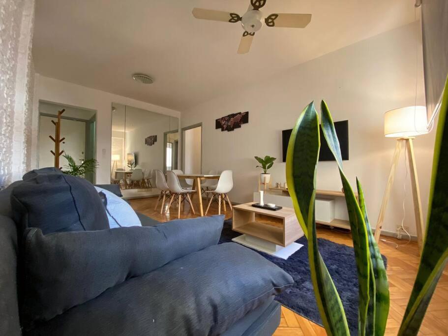 Una sala de estar con un sofá azul y una mesa. en La casita de Valerio, tu lugar, en Buenos Aires