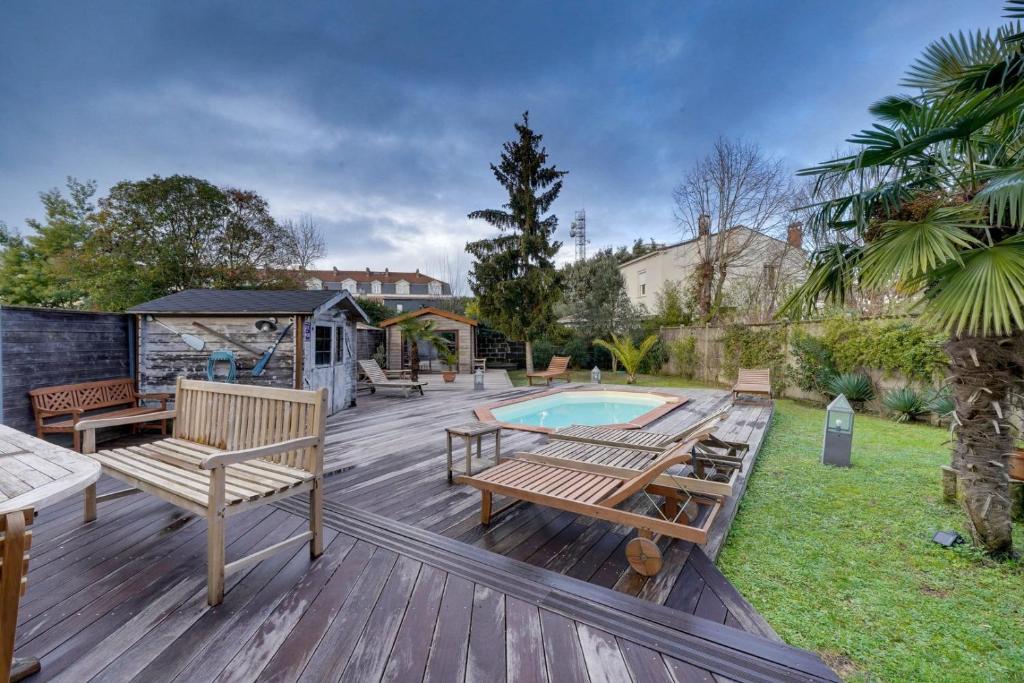 une terrasse en bois avec des bancs et une piscine dans l'établissement Superb loft Bordeaux, à Bordeaux