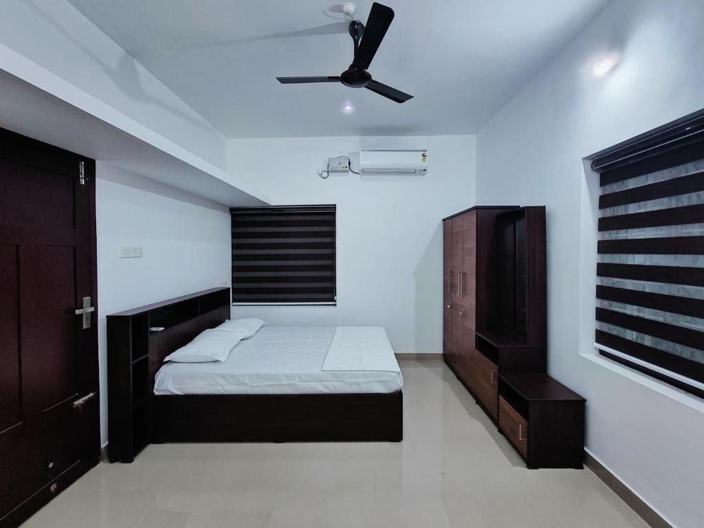 a bedroom with a bed and a ceiling fan at Munroe La Casa in Kollam