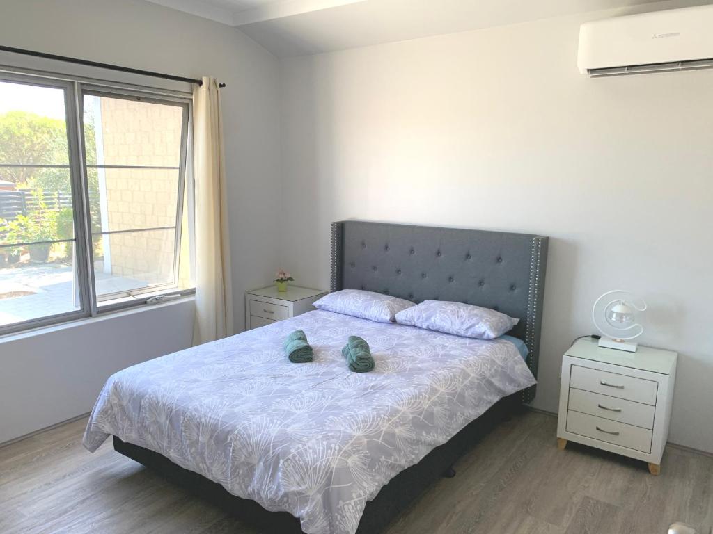 ein Schlafzimmer mit einem Bett mit zwei Schuhen drauf in der Unterkunft West Swan B&B in Perth
