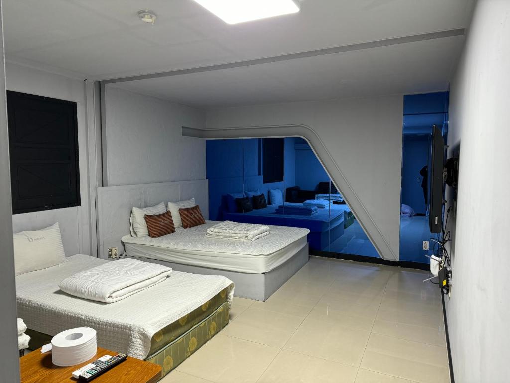 two beds in a room with blue walls at Airtel in Busan