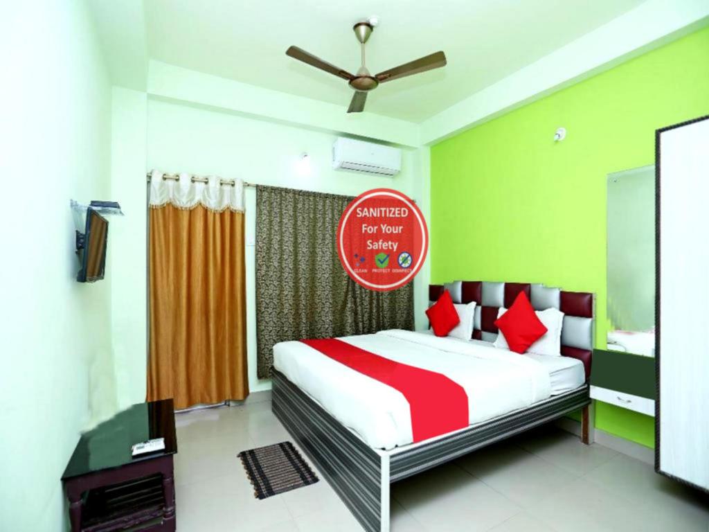 um quarto com uma cama com um cobertor vermelho e branco em Goroomgo Shree Bhumi Puri Near Sea Beach - Best Hotel in Puri em Puri