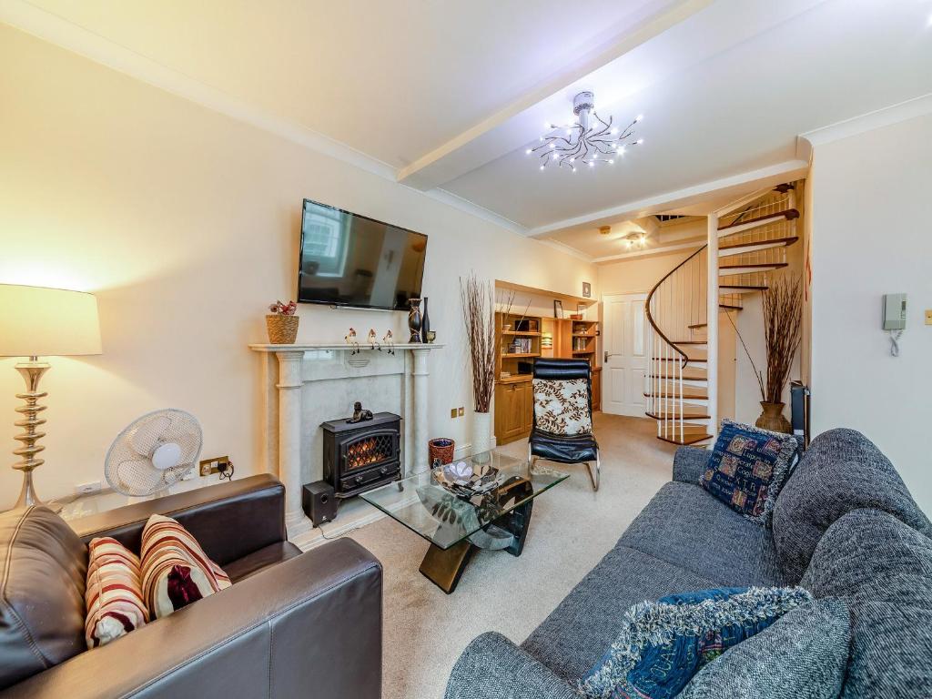 ein Wohnzimmer mit einem Sofa und einem Kamin in der Unterkunft Moonlight Apartment - Uk46023 in Durham