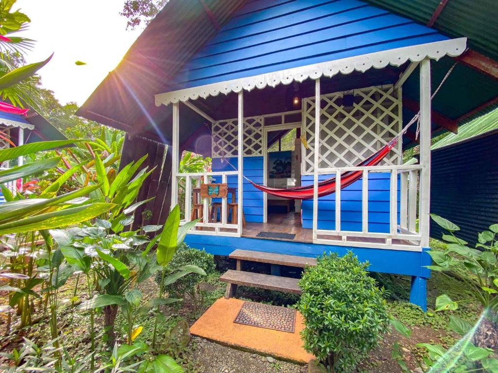 a blue house with a porch with a slide at Hotel Casitas Mar y Luz in Puerto Viejo