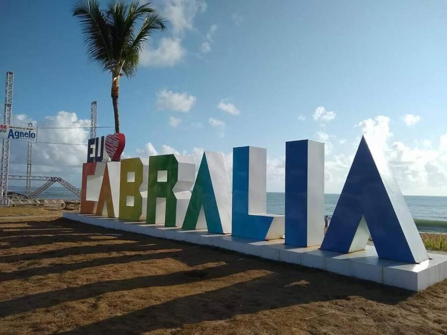 - un grand panneau sur la plage avec un palmier dans l'établissement Casa em Santa Cruz Cabrália, à Santa Cruz Cabrália