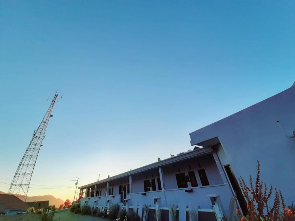ein weißes Gebäude mit einem Kran im Hintergrund in der Unterkunft Sky View Bromo Guest House in Ngadisari
