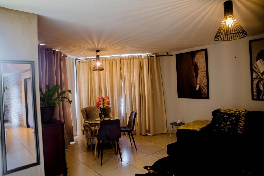 a living room with a couch and a table at One bedroom flat in Wild Olive apartments in Windhoek