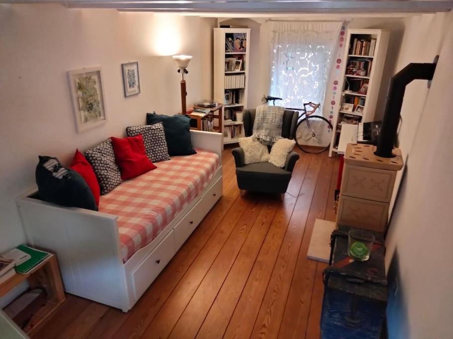 a living room with a couch and wooden floors at Spirit in the sky, a tiny house on the hills in Zago