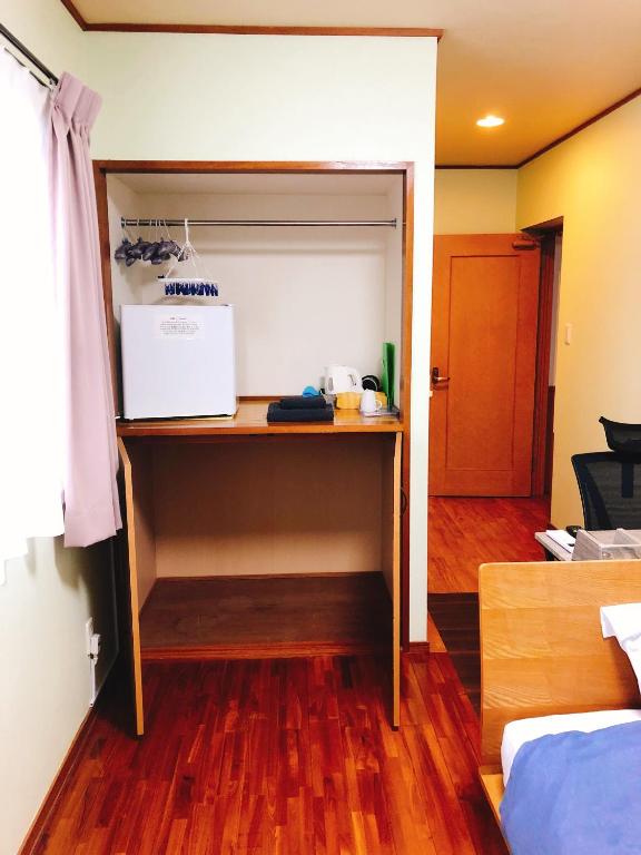 a kitchen with a refrigerator and a microwave in a room at Joya in Ishigaki Island
