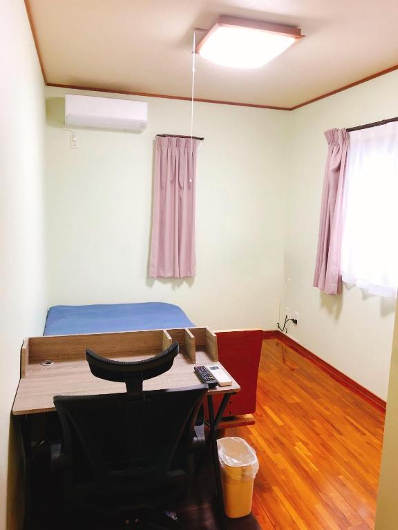 a room with a bed and a desk and a table at Joya in Ishigaki Island
