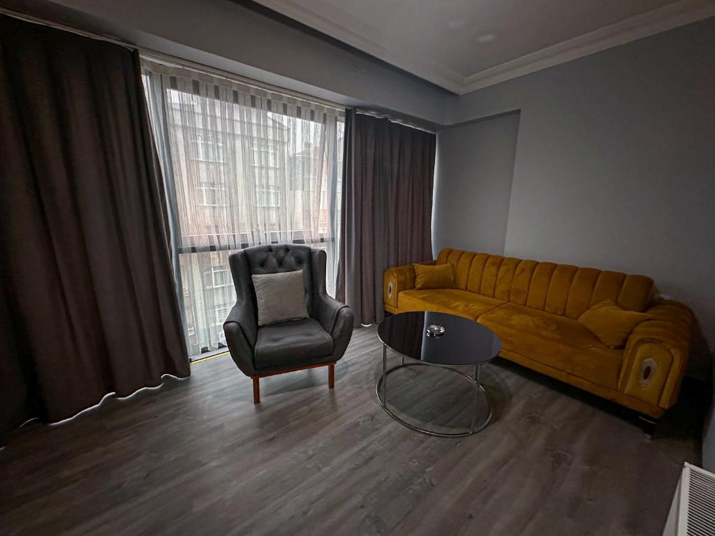 uma sala de estar com um sofá e uma cadeira em Liza Suit Hotel em Istambul