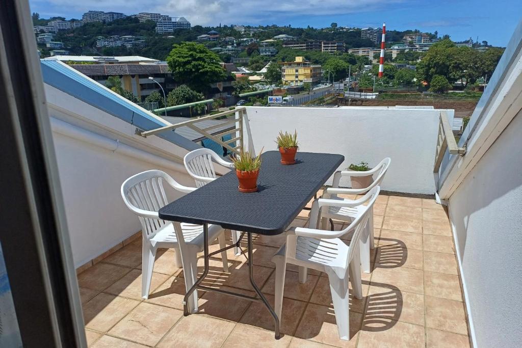 帕皮提的住宿－Fare Gauguin，阳台上配有一张黑桌和白色椅子