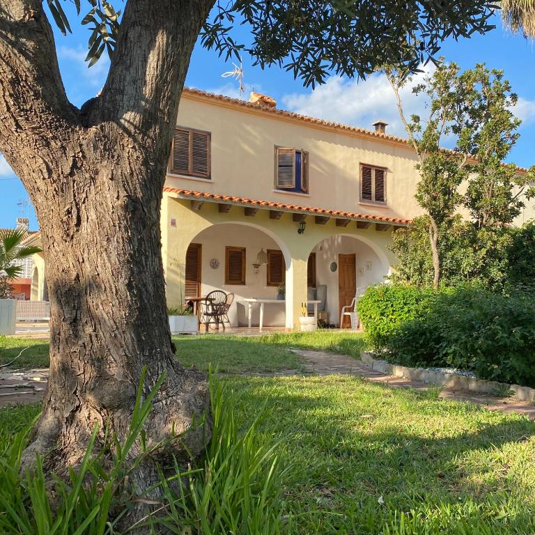 a house with a tree in front of it at La casa de bega de mar in Sueca
