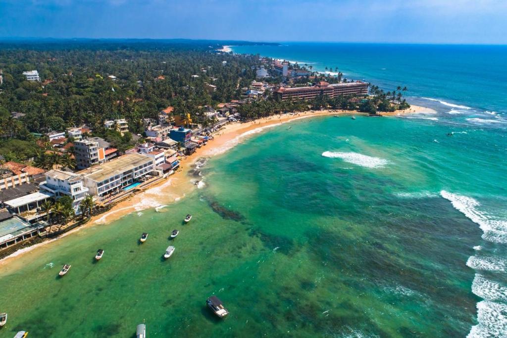 an aerial view of a beach with boats in the water at Happy Stay Holiday Inn in Hikkaduwa