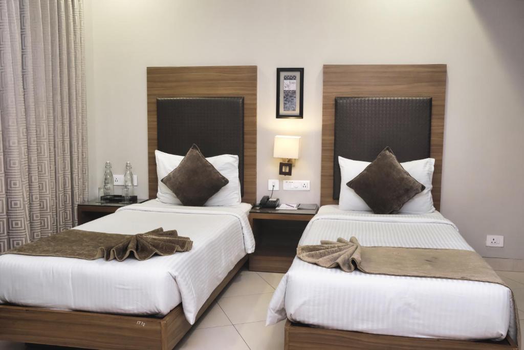 Postel nebo postele na pokoji v ubytování Peerless Hotel Durgapur