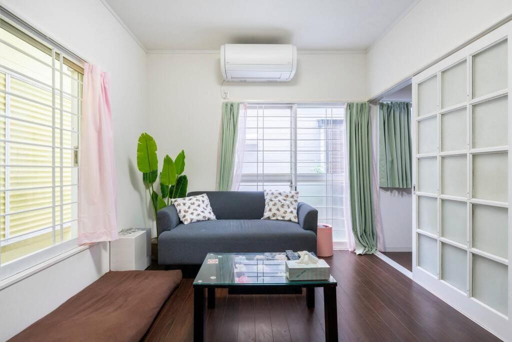 a living room with a blue couch and a table at アンドステイ柴又5丁目B in Tokyo