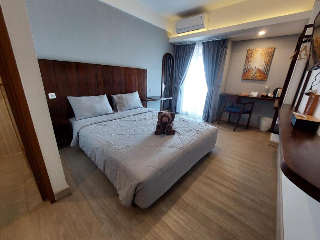 a hotel room with a bed with a backpack on it at Sienna Residence Bogor in Kedungbadak