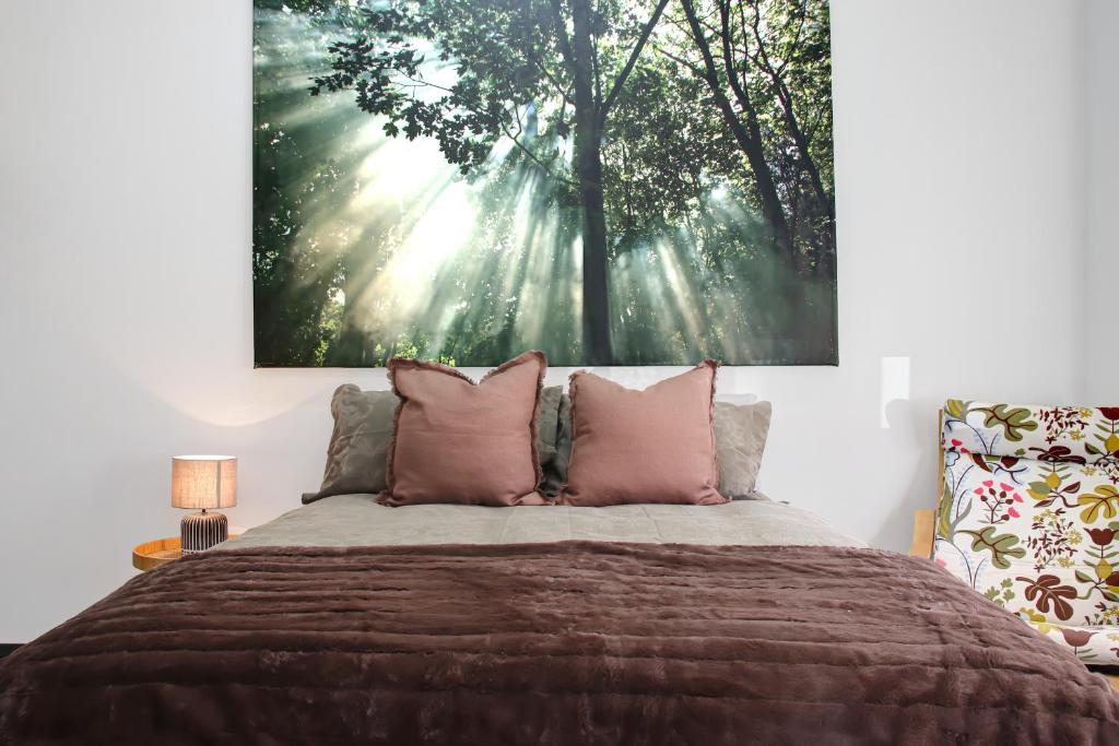 een slaapkamer met een bed met een grote foto aan de muur bij Thomson Rest in Belmont