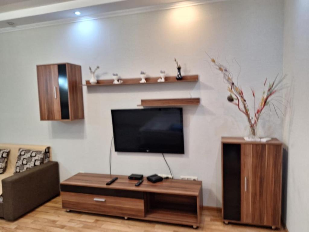 a living room with a flat screen tv on a wall at ЖК Сункар in Almaty