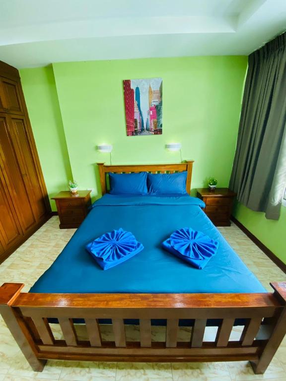 a bedroom with a blue bed with blue pillows at BT hotel Kata Beach in Kata Beach