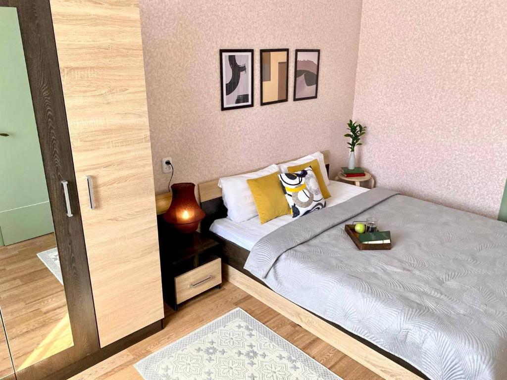 Un pequeño dormitorio con una cama y una puerta abierta en Уютная двушка в центре, en Temirtaū
