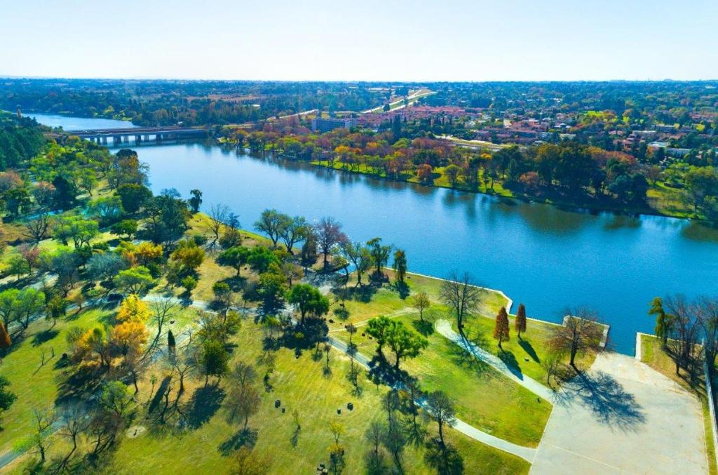 an aerial view of a river with trees and a city at The View on Vaal Resort in Sasolburg