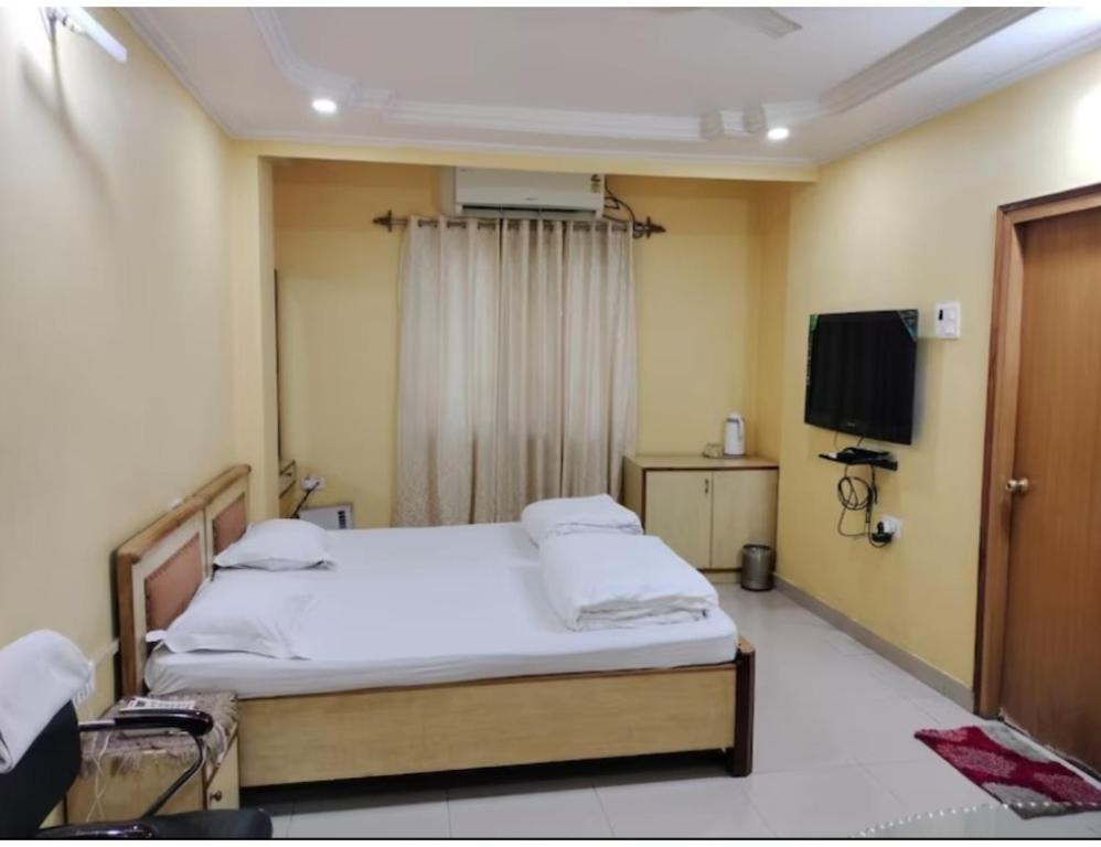 a hospital room with a bed and a television at Hotel Gharana, Gaya in Gaya