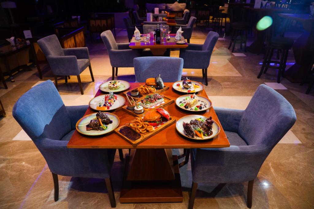 a table with plates of food on it in a restaurant at Stella Di Mare Dubai Marina Hotel in Dubai