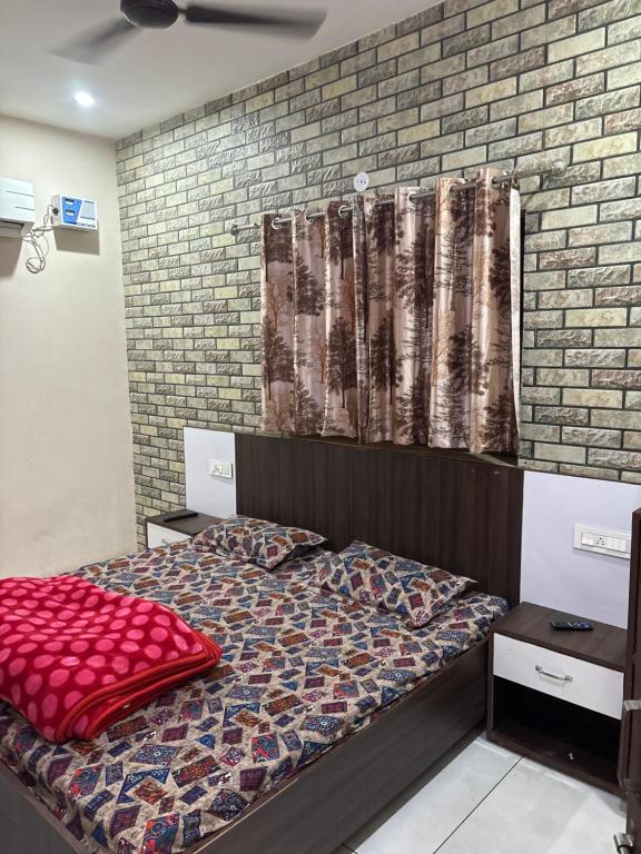 een slaapkamer met een bed en een bakstenen muur bij NAGPAL GUEST HOUSE in Ludhiana