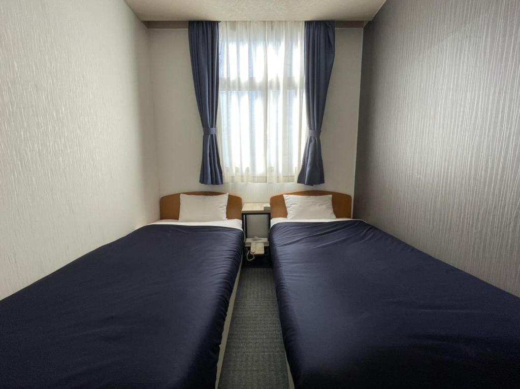Postel nebo postele na pokoji v ubytování Zentsuji Grand Hotel