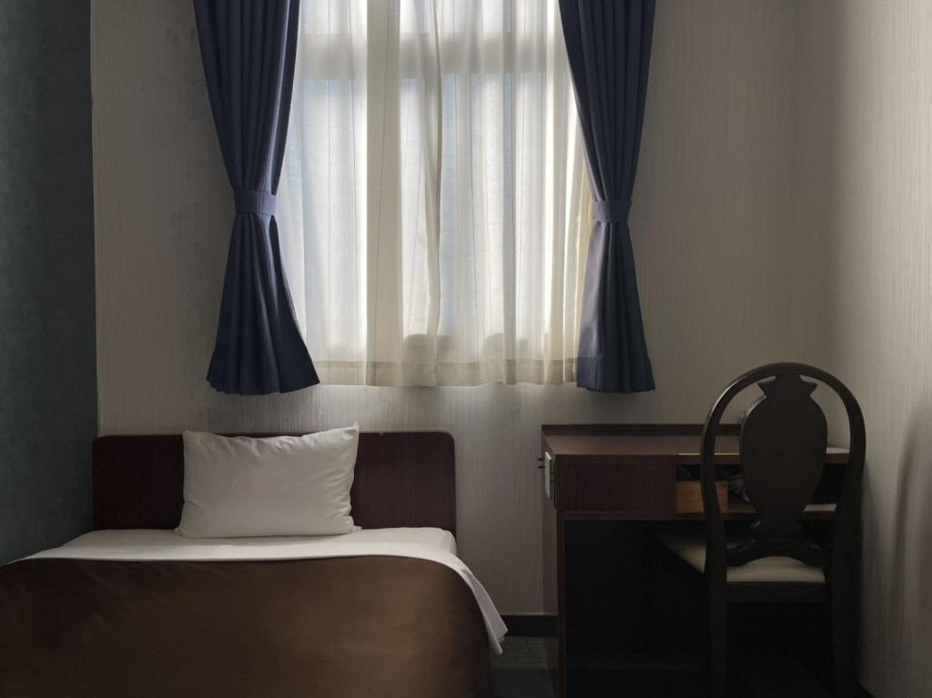 Postel nebo postele na pokoji v ubytování Zentsuji Grand Hotel