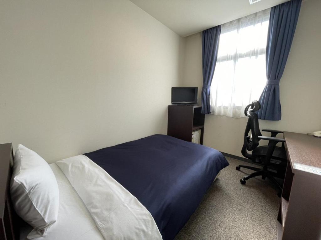 Postel nebo postele na pokoji v ubytování Zentsuji Grand Hotel