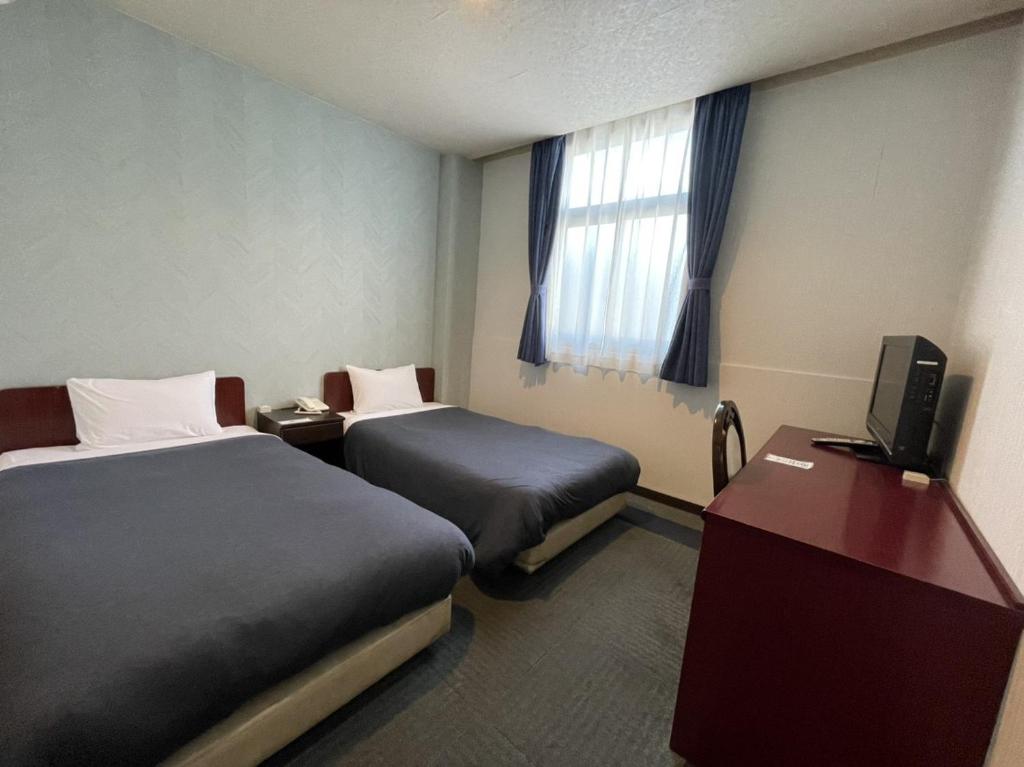 Postel nebo postele na pokoji v ubytování Zentsuji Grand Hotel