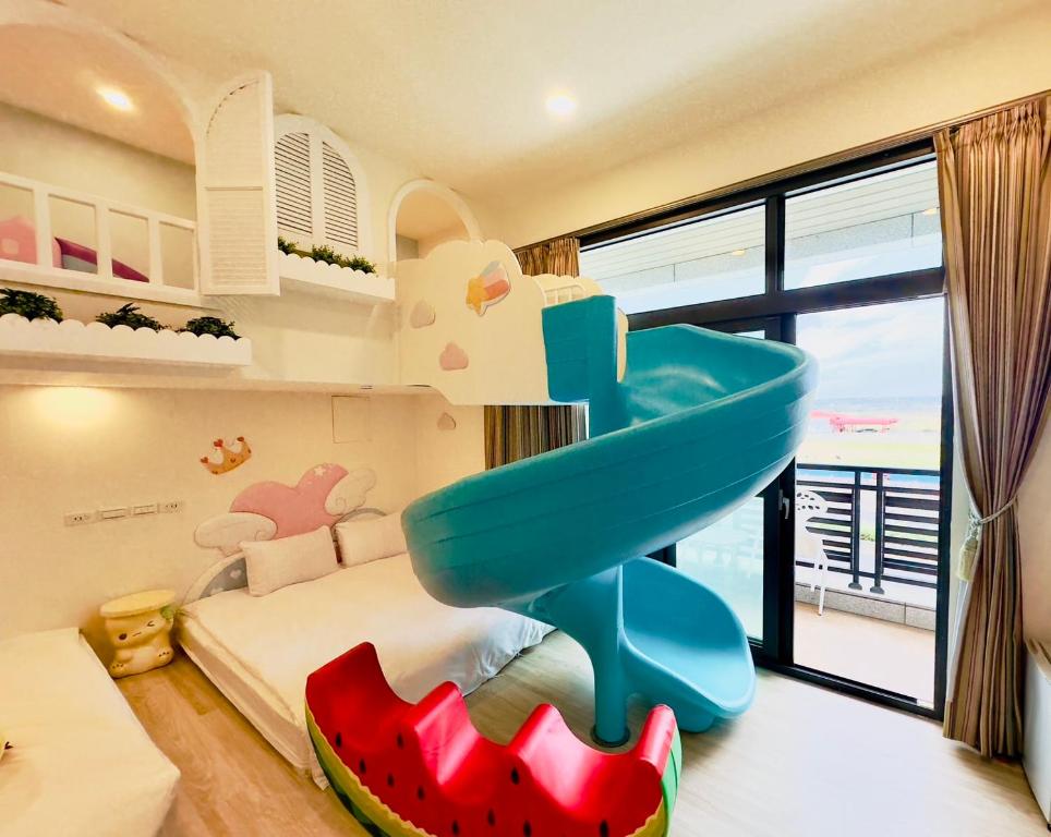 a childs bedroom with a blue slide in it at Sun Shine B&B in Hengchun